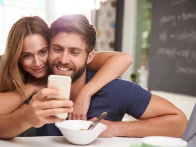 Couple Eating Breakfast Using Digital Tablet And Phone